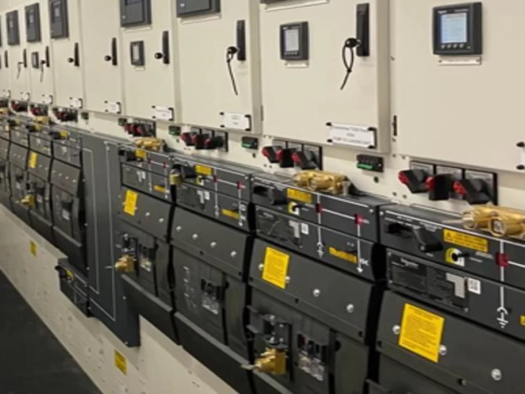 A run of distribution switchgear with instrumentation, switches and safety labelling.